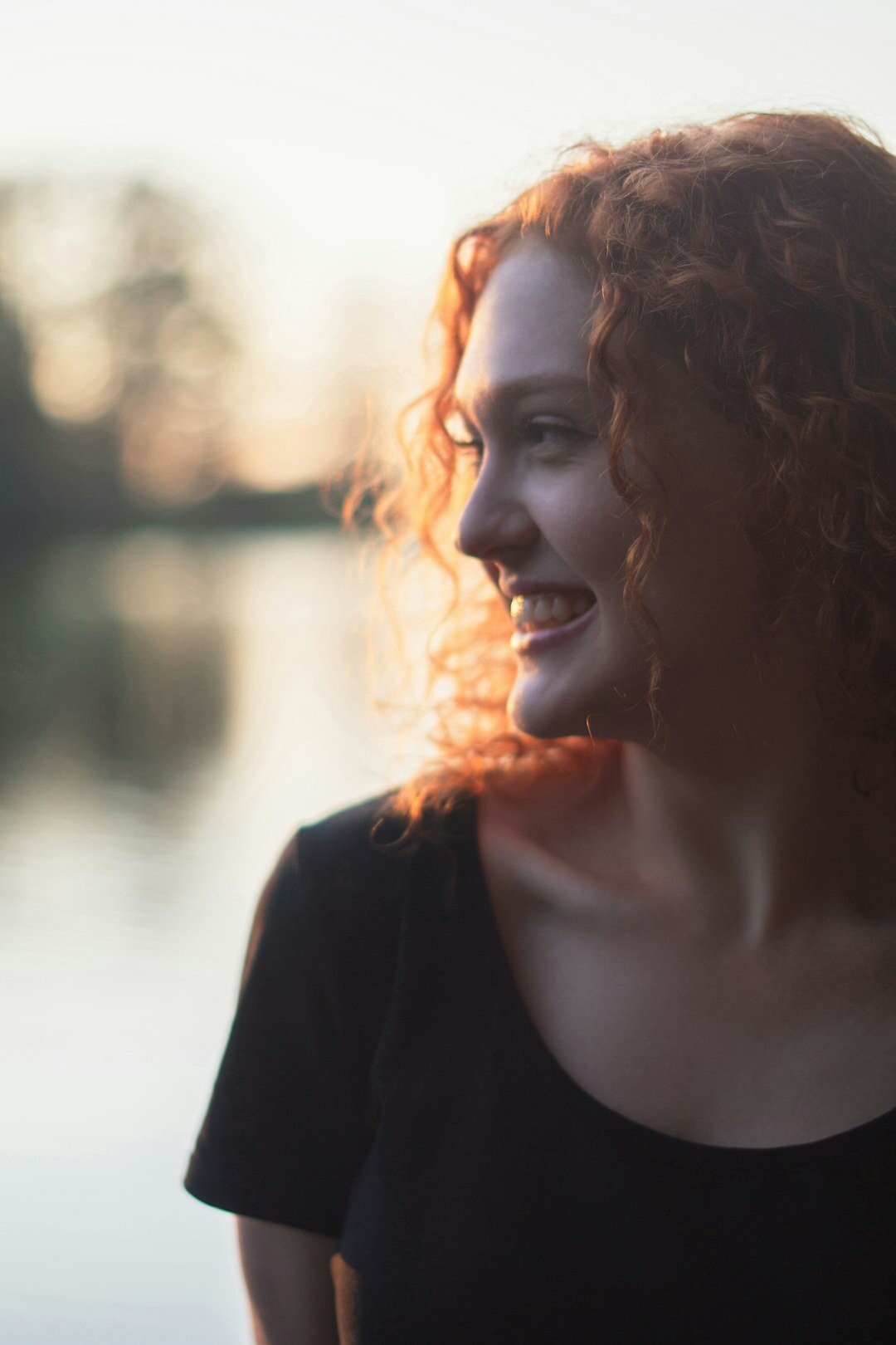 Portrait einer lächelnden Frau mit lockigem Haar, die in die Kamera blickt